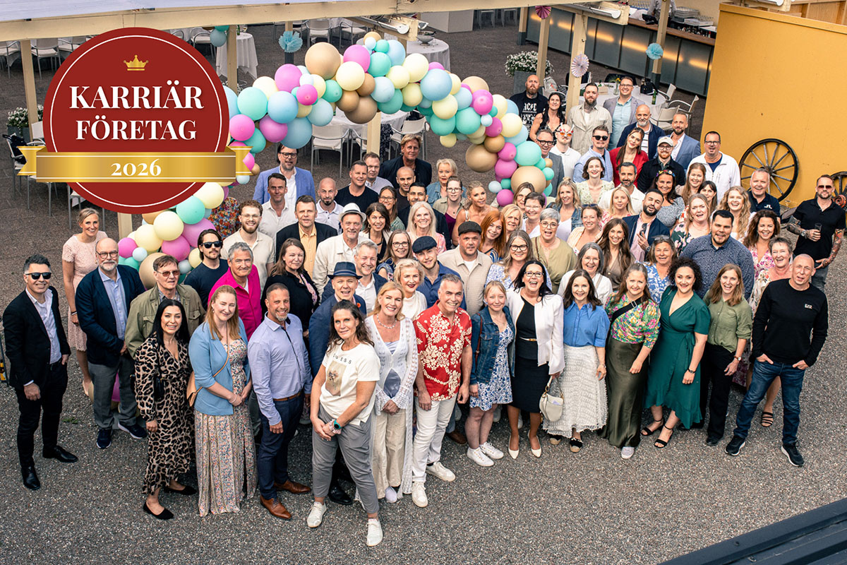 En grupp festklädda människor under en ballongbåge med Karriärföretagens certifikat.