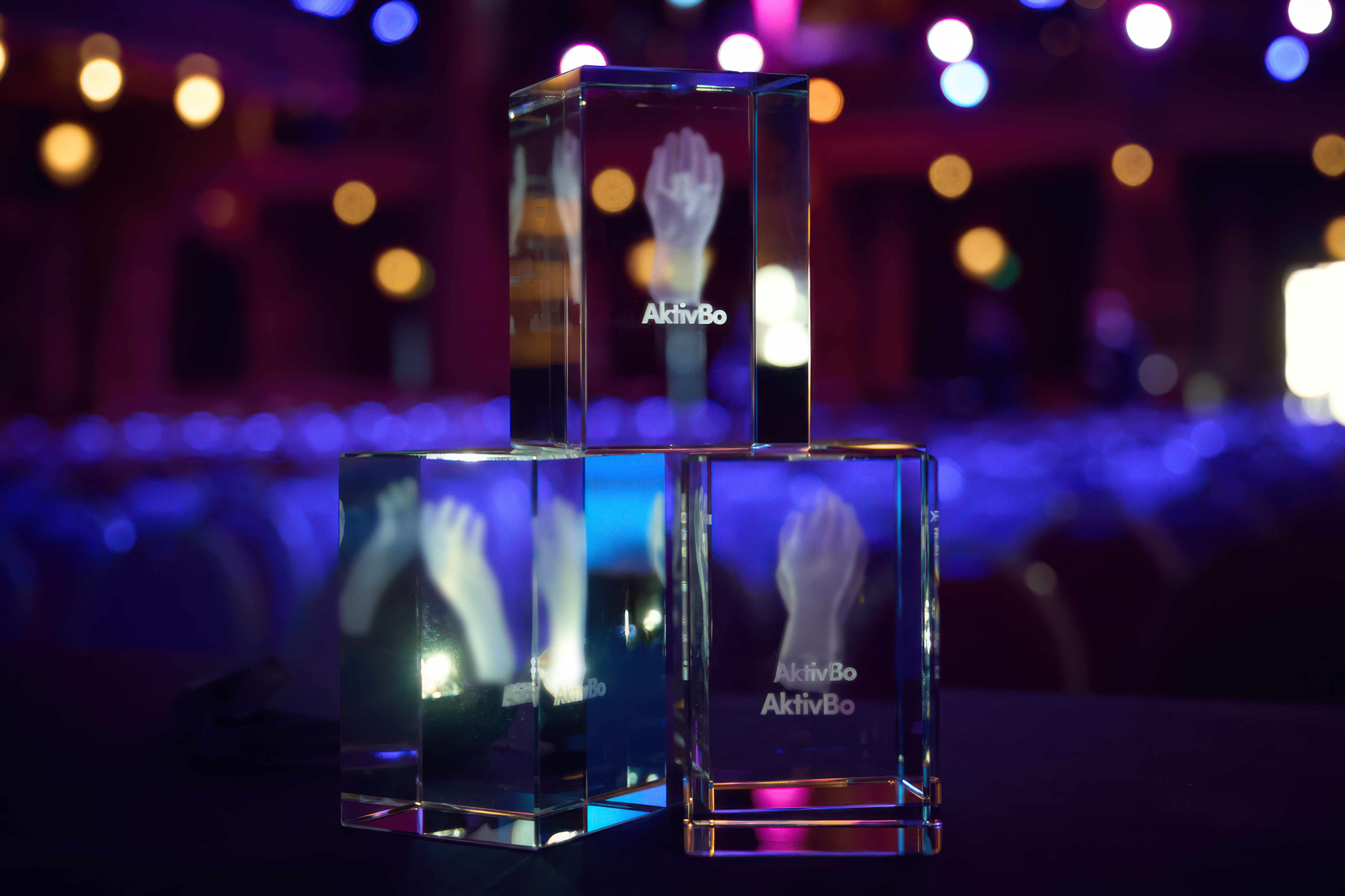 Tre glaskuber staplade på varandra mot en mörk bakgrund.